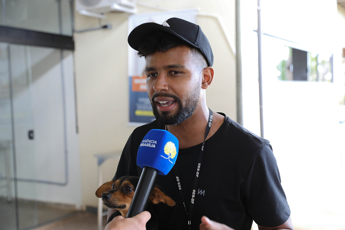Homem dá entrevista para a Agência Brasília com um cachorro no colo